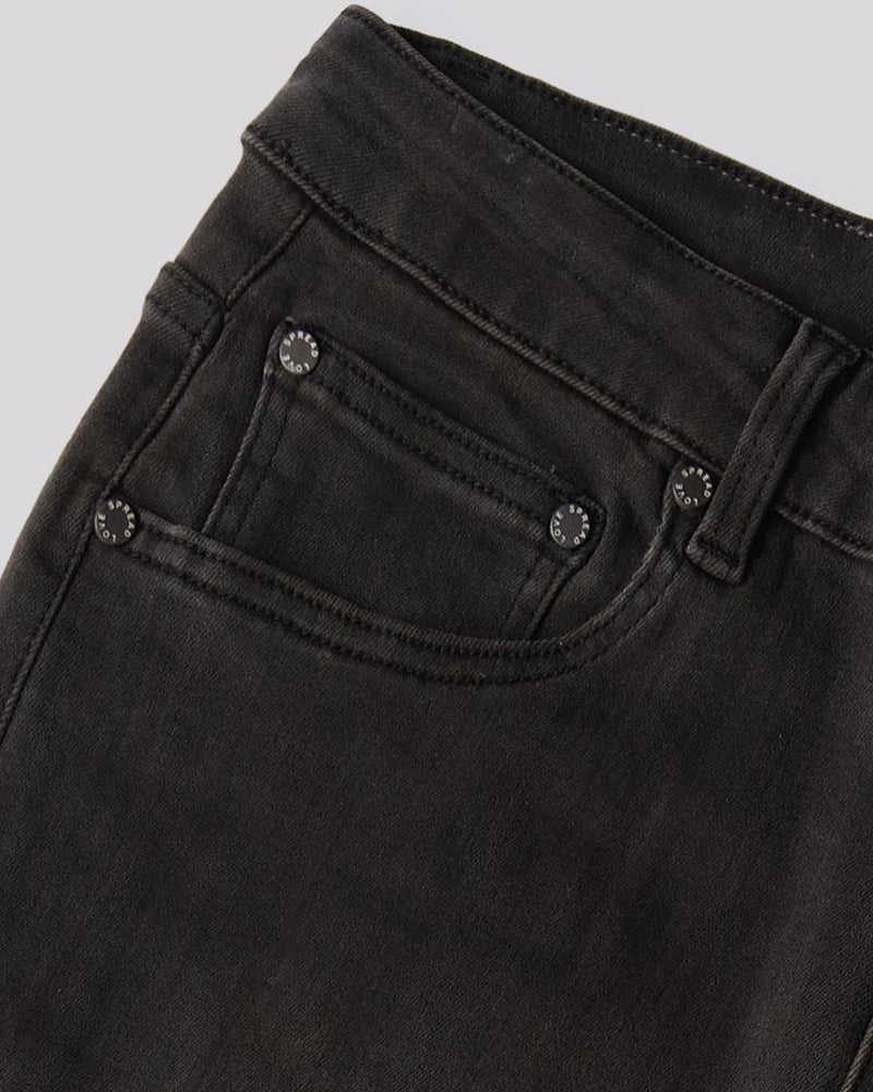 Close-up of a pair of faded black denim jeans showing the waistband, belt loops, and front pocket with metal rivets.