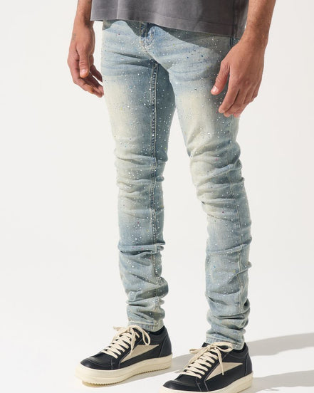 Person wearing light blue jeans and black sneakers on a white background