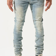 Person wearing light blue distressed jeans and black sneakers on a white background