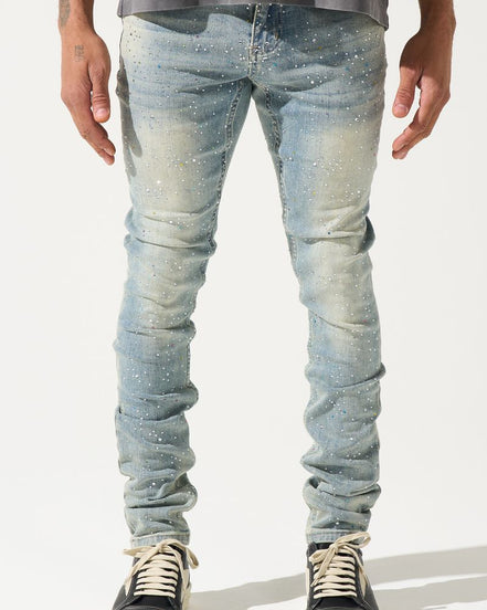 Person wearing light blue distressed jeans and black sneakers on a white background