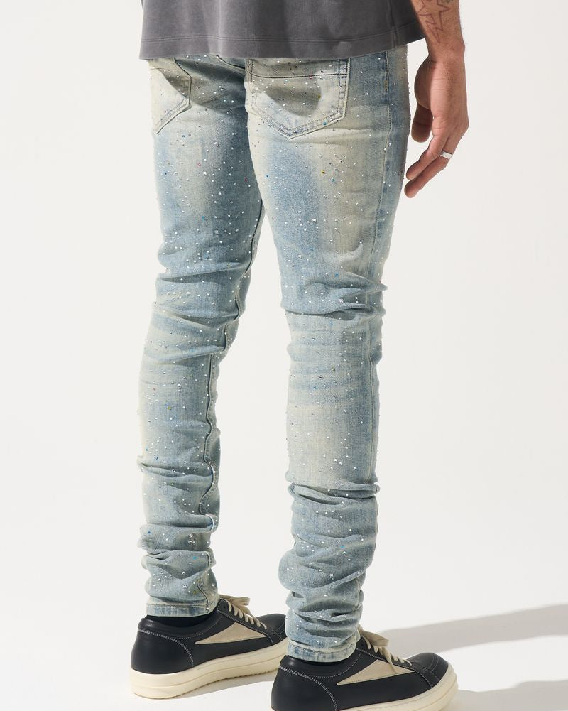 Person wearing light blue distressed jeans and black sneakers on a white background