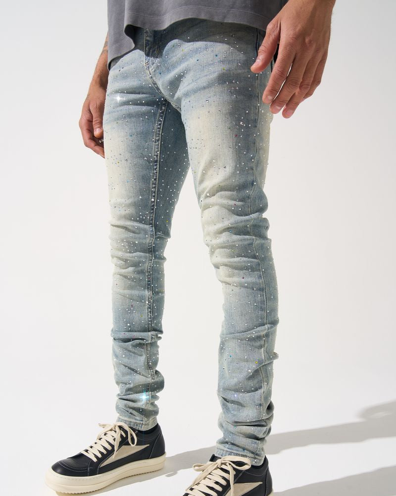 Person wearing light blue distressed jeans and black sneakers on a white background
