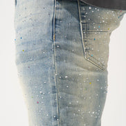 Close-up of light blue jeans with rhinestone embellishments on a white background