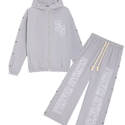 A two-piece light gray tracksuit set featuring a zip-up hooded jacket and matching drawstring pants. The jacket has a white 'FS' monogram on the chest, and the pants feature 'FOREVER SITUATED' printed vertically in white on one leg.