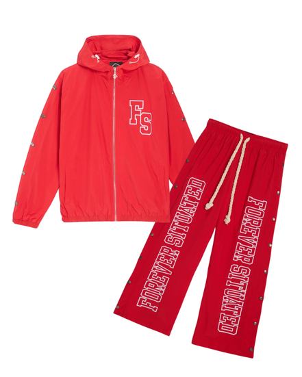 A red two-piece tracksuit set featuring a zip-up hooded jacket and matching pants. The jacket has a white 'FS' logo on the chest, while the pants feature 'FOREVER SITUATED' printed in white varsity letters down the left leg.