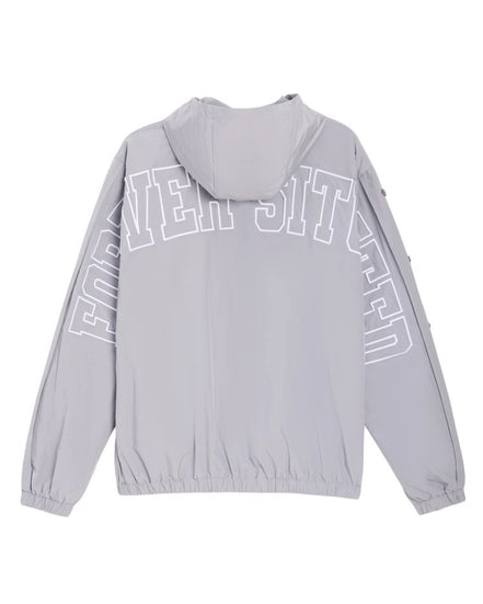 A light gray hooded windbreaker jacket shown from the back, featuring large white outlined text arched across the upper back and sleeves.