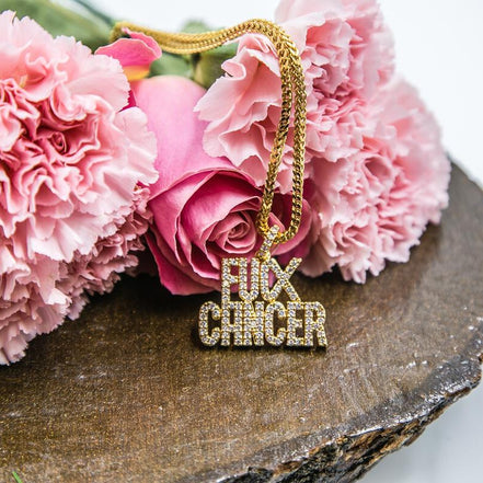 Gold necklace with 'F**K CANCER' pendant on pink flowers