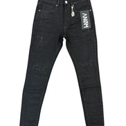 Black distressed skinny jeans with ripped details and a white hangtag on the pocket, displayed flat against a white background.