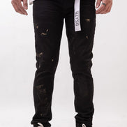 Person wearing black distressed jeans with a visible brand label on a white background