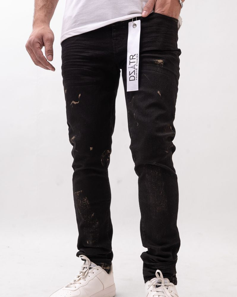 Person wearing black distressed jeans with a visible brand tag on a white background