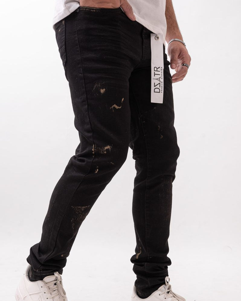 Person wearing black distressed jeans with a visible brand label on a white background