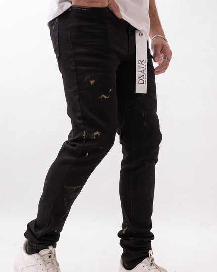 Person wearing black distressed jeans with a visible brand label on a white background