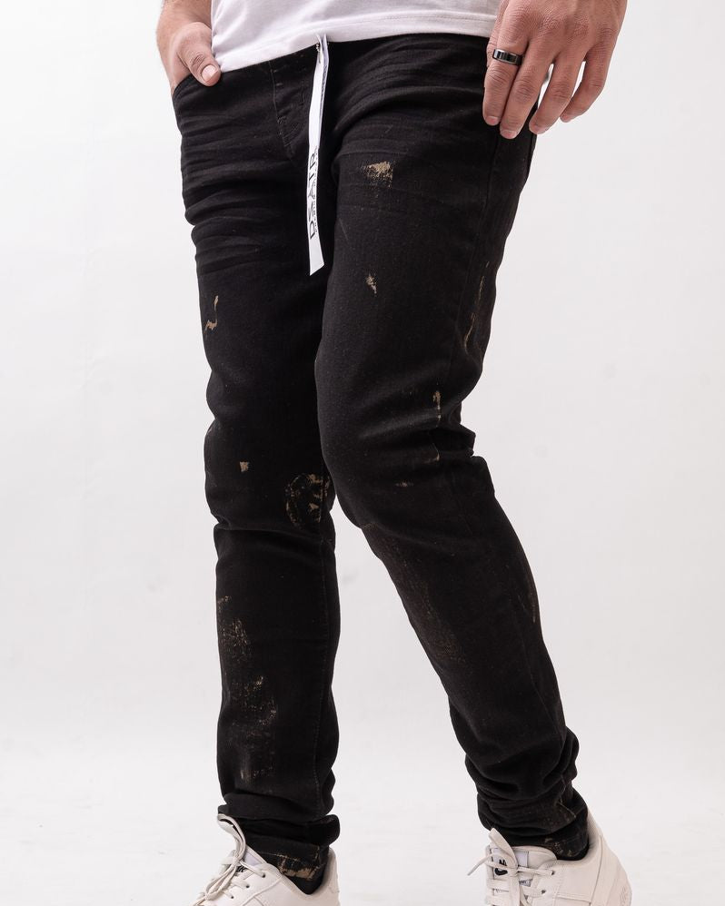 Person wearing black distressed jeans and white sneakers on a white background