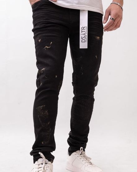 Person wearing black distressed jeans with a visible brand logo on a white background