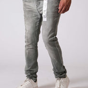Person wearing gray jeans and white sneakers on a plain background