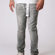 Person wearing light gray jeans with a visible brand label on a white background