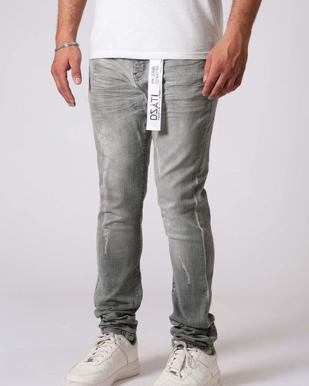 Person wearing light gray jeans with a visible brand label on a white background