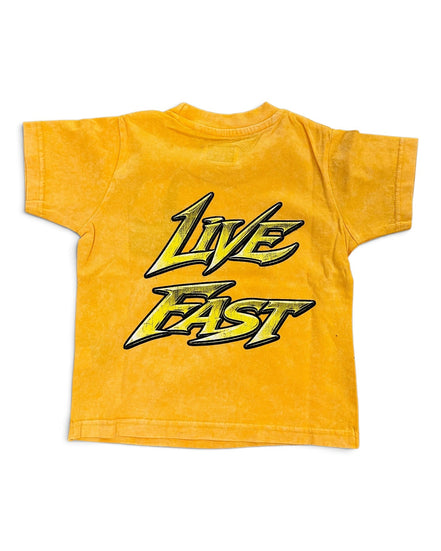 A yellow short-sleeve t-shirt with a faded texture, featuring a large 'LIVE FAST' graphic printed on the front in a stylized black and yellow font, set against a plain white background.