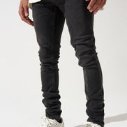 Person wearing black jeans and white sneakers on a white background