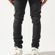 Person wearing black jeans and white sneakers on a white background