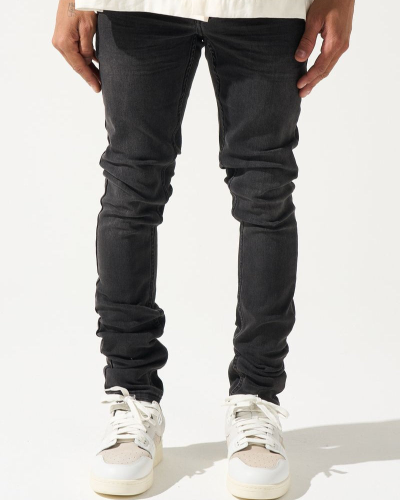 Person wearing black jeans and white sneakers on a white background