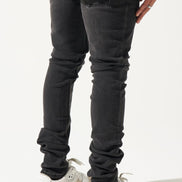 Person wearing black jeans and white sneakers on a white background