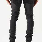 Person wearing black jeans and white sneakers on a plain background