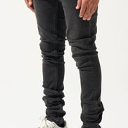Person wearing black jeans and white sneakers on a white background