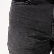 Close-up of dark gray jeans on a white background