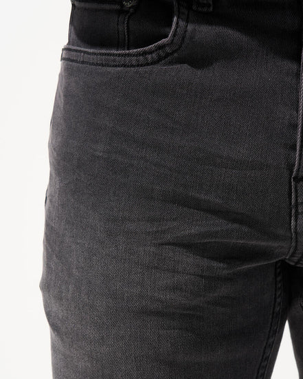 Close-up of dark gray jeans on a white background