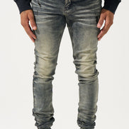 Person wearing gray distressed jeans and black high-top sneakers on a white background