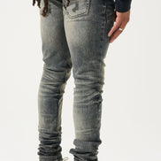 Person wearing gray jeans and black sneakers with red heart designs on a white background
