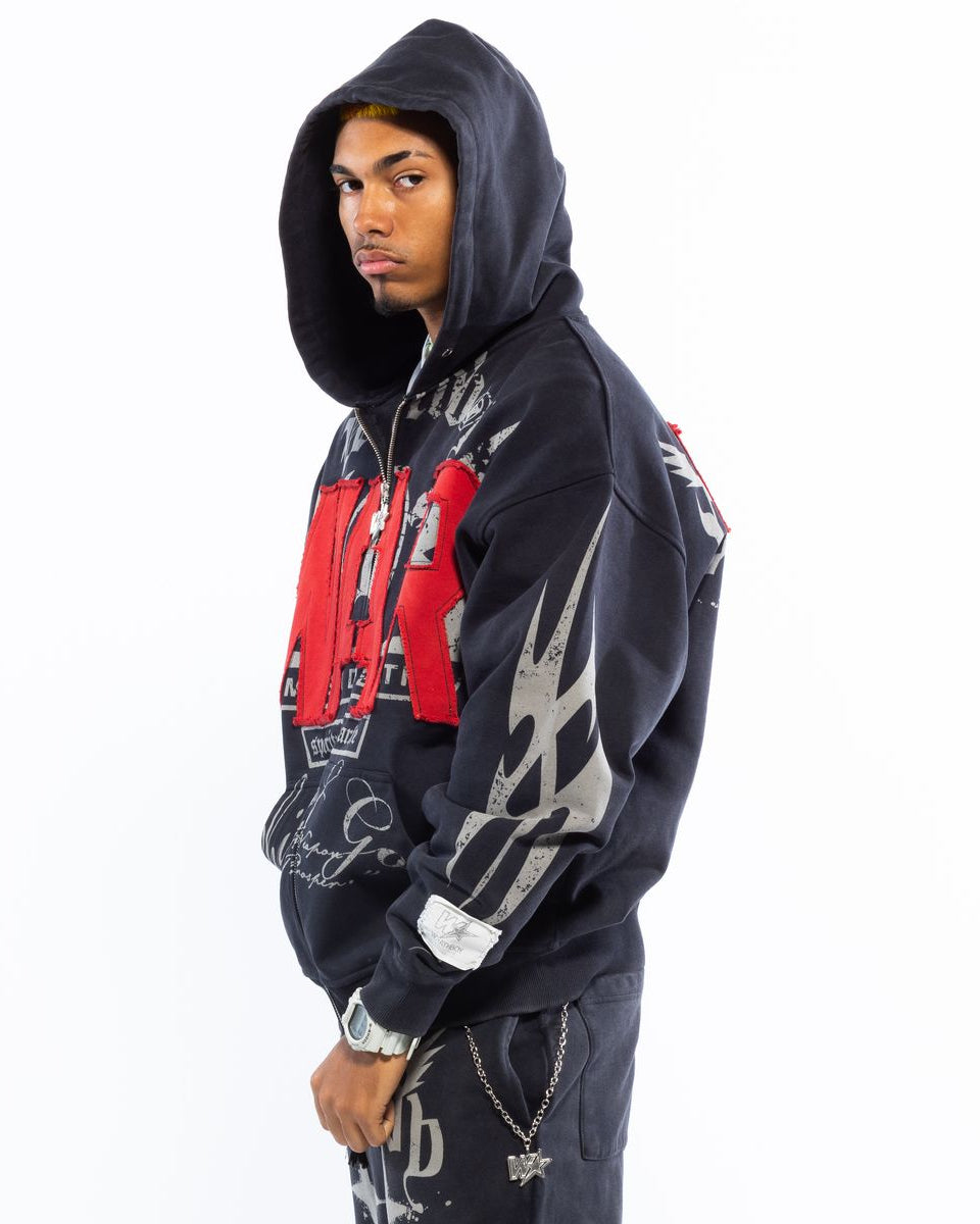 Person wearing a black hoodie with graphic designs on a white background