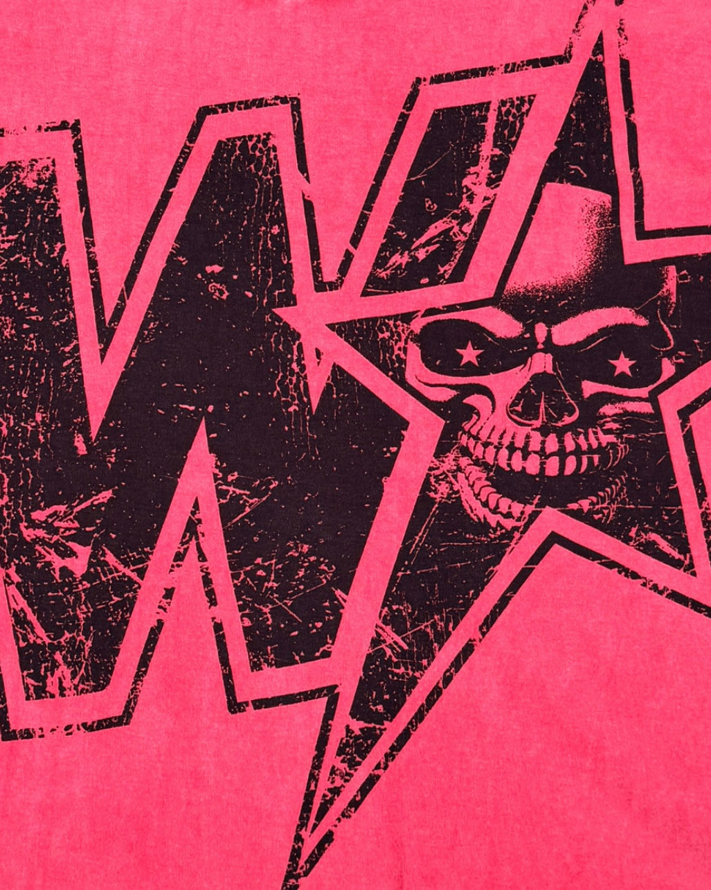 A close-up of a graphic print featuring a black distressed skull inside a star outline, set against a vibrant red wash background with a large black letter 'W' partially visible.