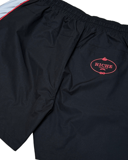 Black shorts with a red logo on a white background