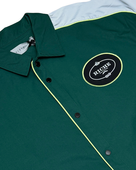 Green jacket with a logo patch on a white background