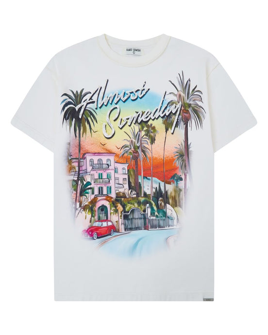 White t-shirt with a colorful graphic design of a beach scene and text on a white background