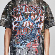 Person wearing a graphic t-shirt with a prominent design on a plain background