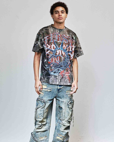 Person wearing a graphic t-shirt and distressed jeans against a plain background