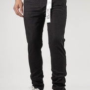 Person wearing black pants with a brand tag on a white background