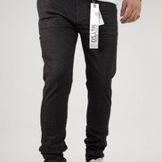 Person wearing black pants with a visible brand tag on a white background