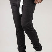 Person wearing black pants with a visible brand tag on a white background