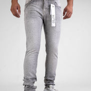 Person wearing gray jeans with a visible brand tag on a white background