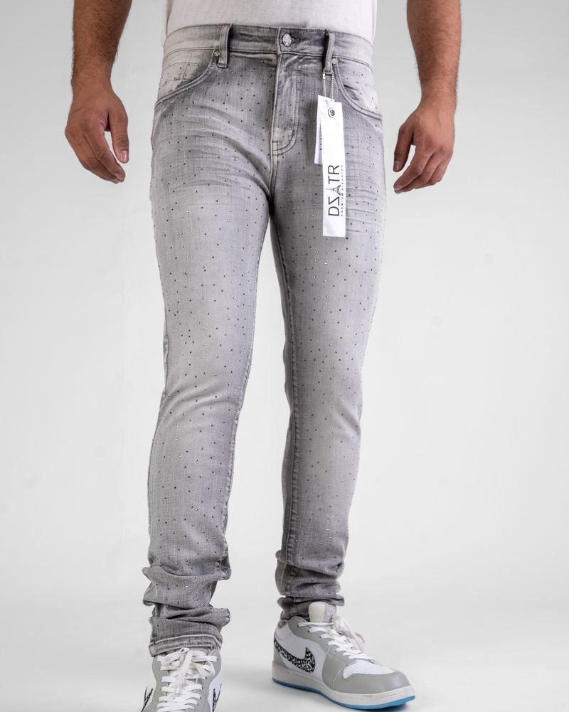 Person wearing gray jeans with a visible brand tag on a white background