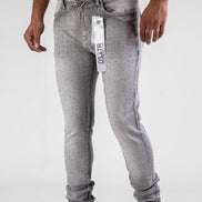 Person wearing gray jeans with a visible brand label on a white background