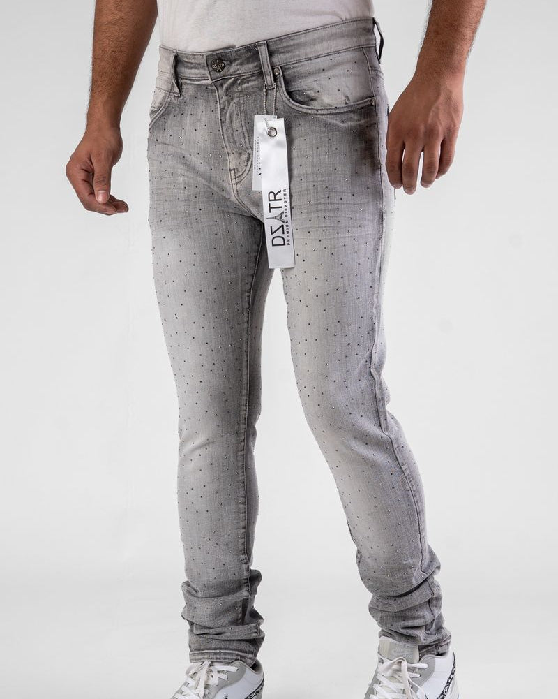Person wearing gray jeans with a visible brand label on a white background