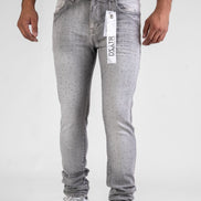 Person wearing gray jeans with a visible brand tag on a white background