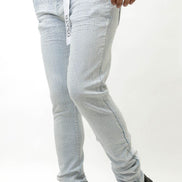 Person wearing ice blue pants and black shoes on a white background