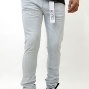 Person wearing ice blue jeans with a brand label on a white background