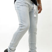 Person wearing ice blue jeans with a brand logo on a white background